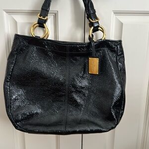 The Original Car Shoe black patent handbag with gold accents